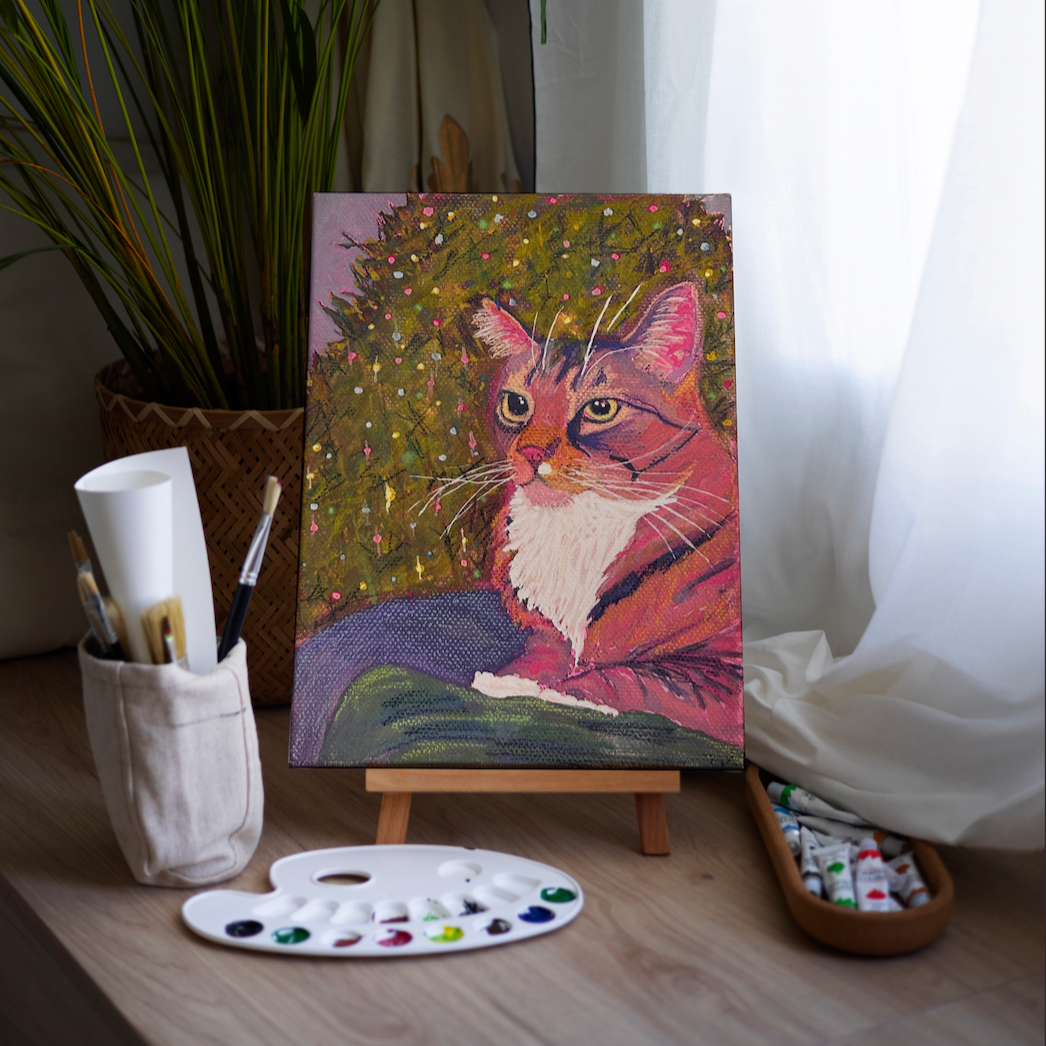 Painting of a cat on an easel with art supplies in a room setting